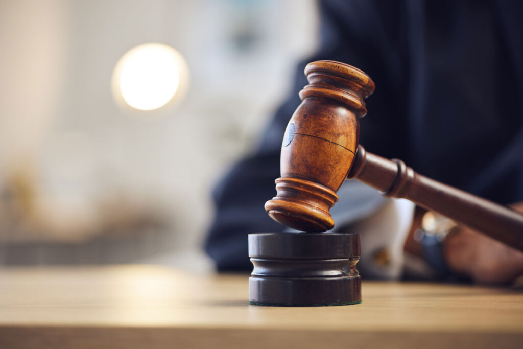 A gavel rests on its block in a courtroom.