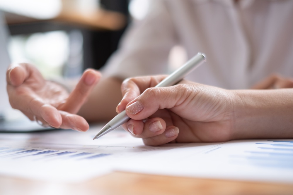 Two people filling out bail paperwork on desk