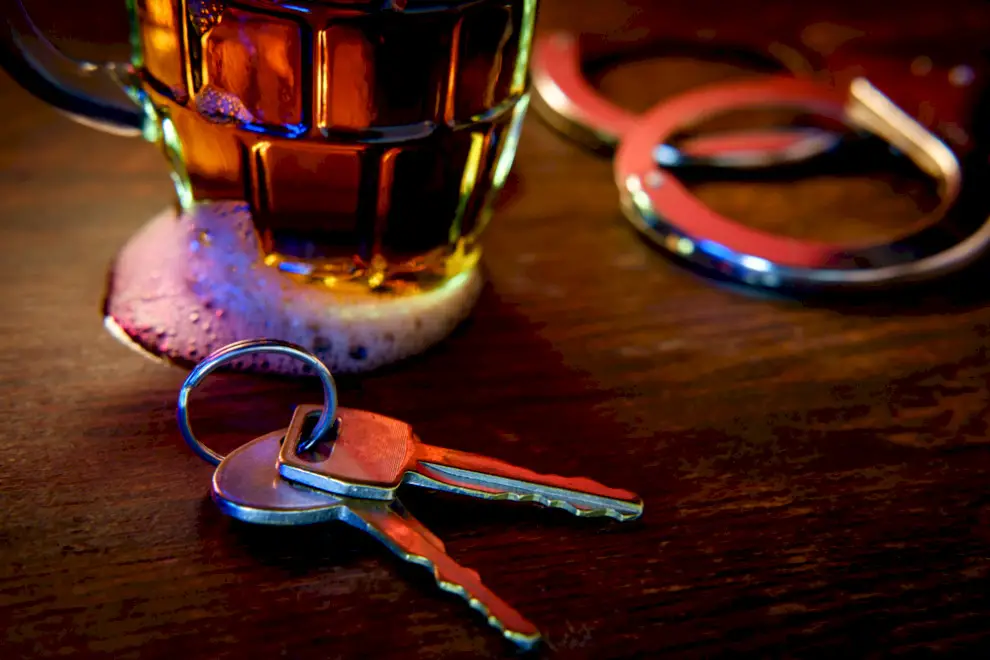 Car keys sitting beside full pint of beer