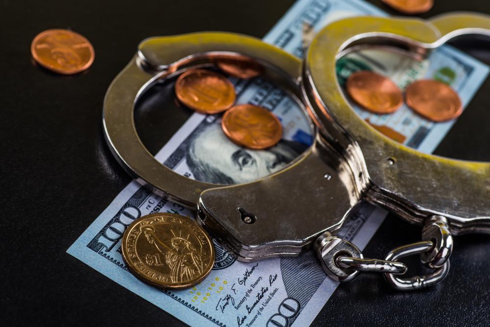 A pair of handcuffs lying on top of a pile of money