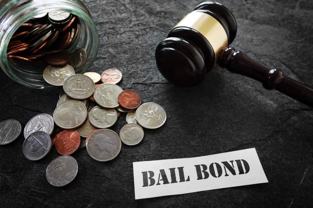 Bail bond note on table with gavel and coins scattered around the surface