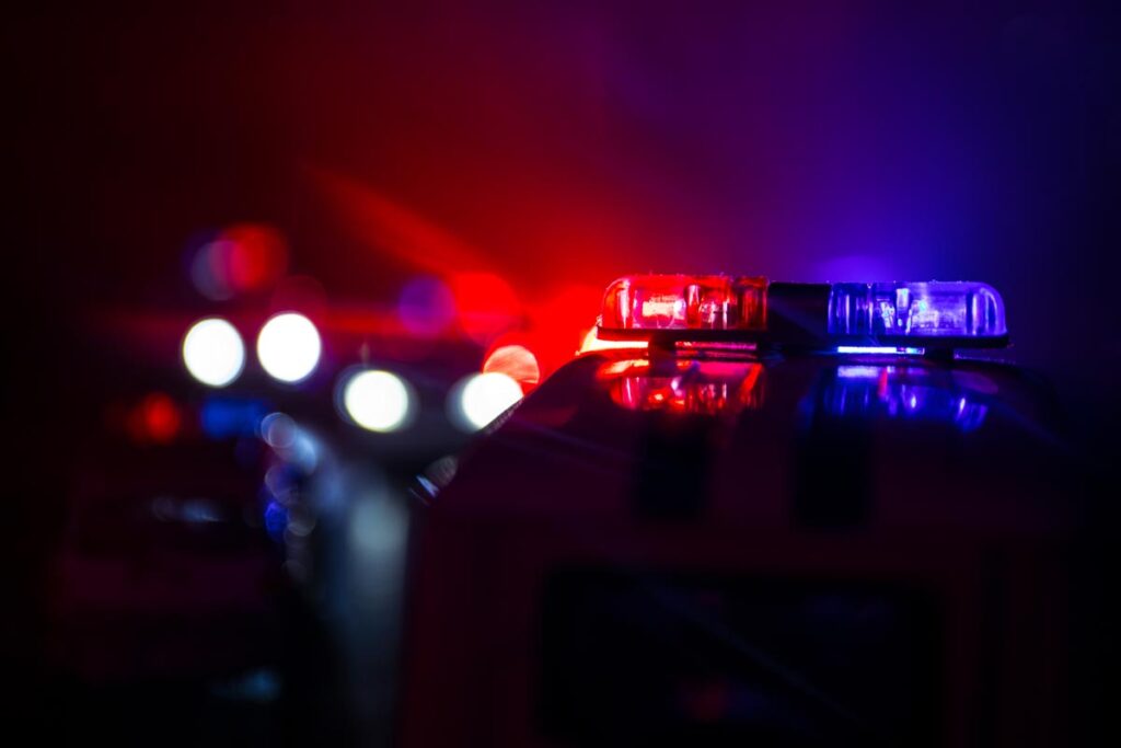 A police car at night dark background blue and red flashing lights emergency response
