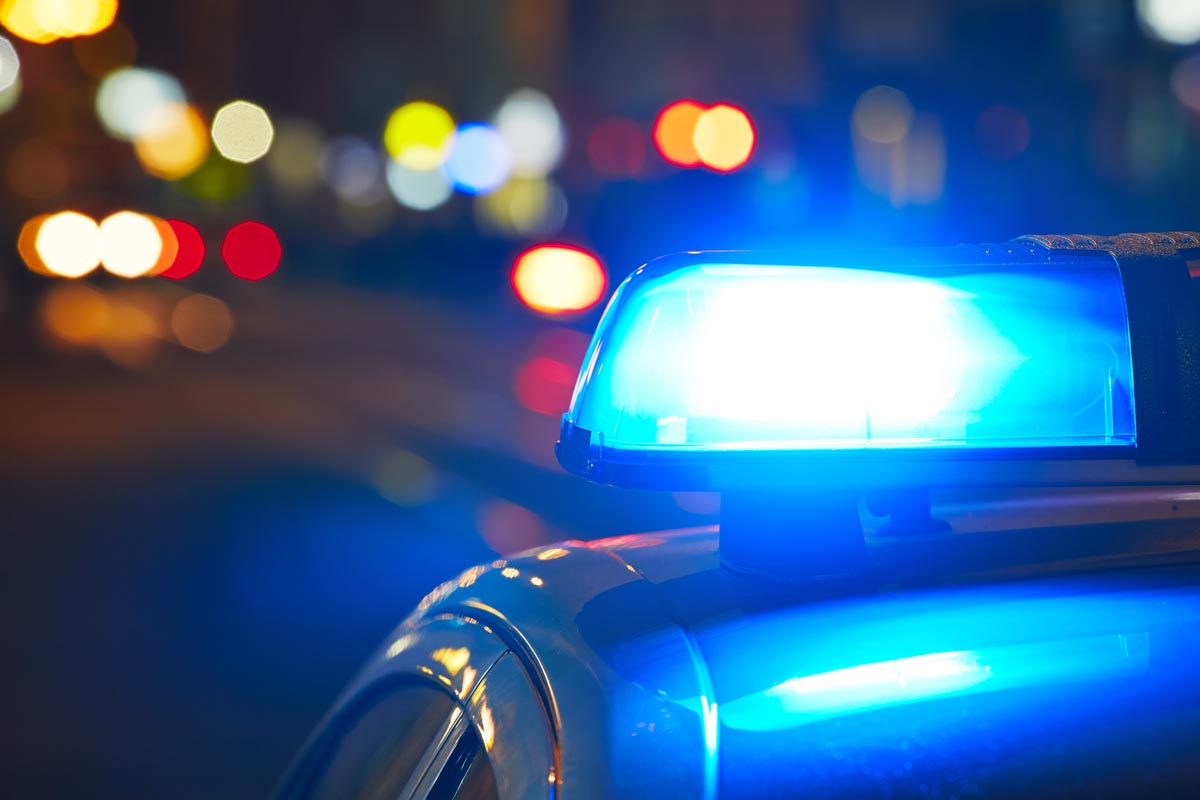 Police car at night blue flashing light responding to emergency call