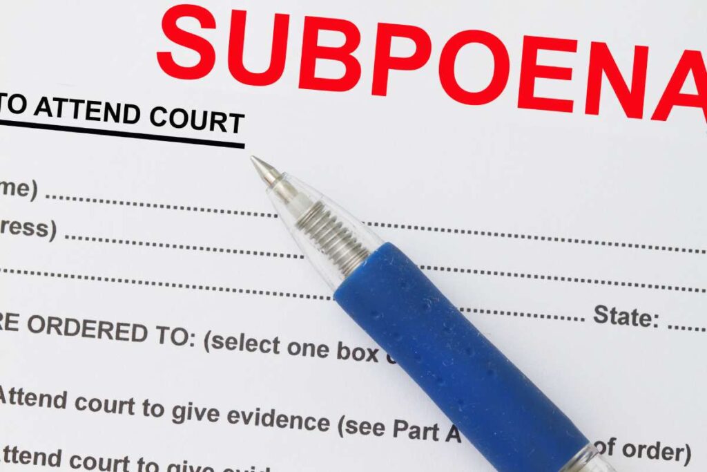 Close-up on a subpoena document with a blue pen sitting on top