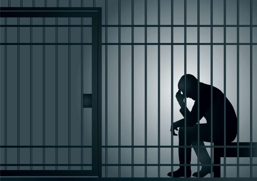 Silhouette of a sad prisoner in a sparse jail cell