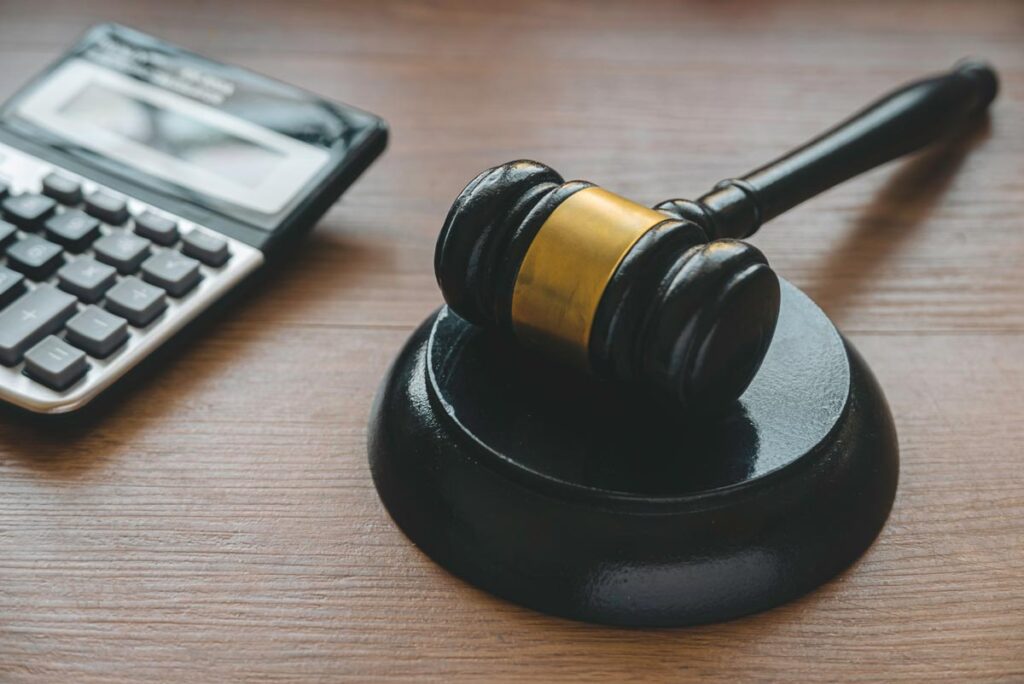 A gavel sits next to a calculator, suggesting the concept of bail bonds.