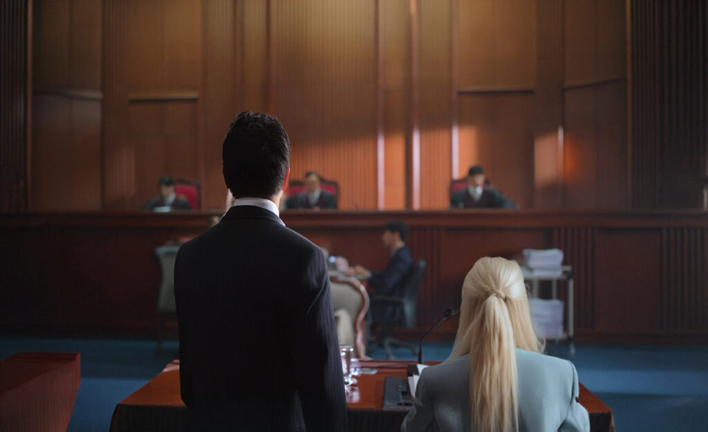 A lawyer speaks to a judge in a courtroom.