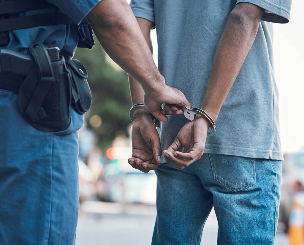 A policeman handcuffing a man.