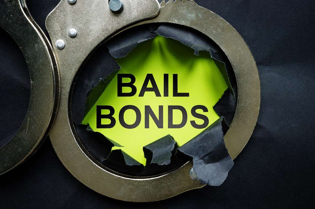 The words “Bail Bonds” are seen on a green background underneath a set of handcuffs.