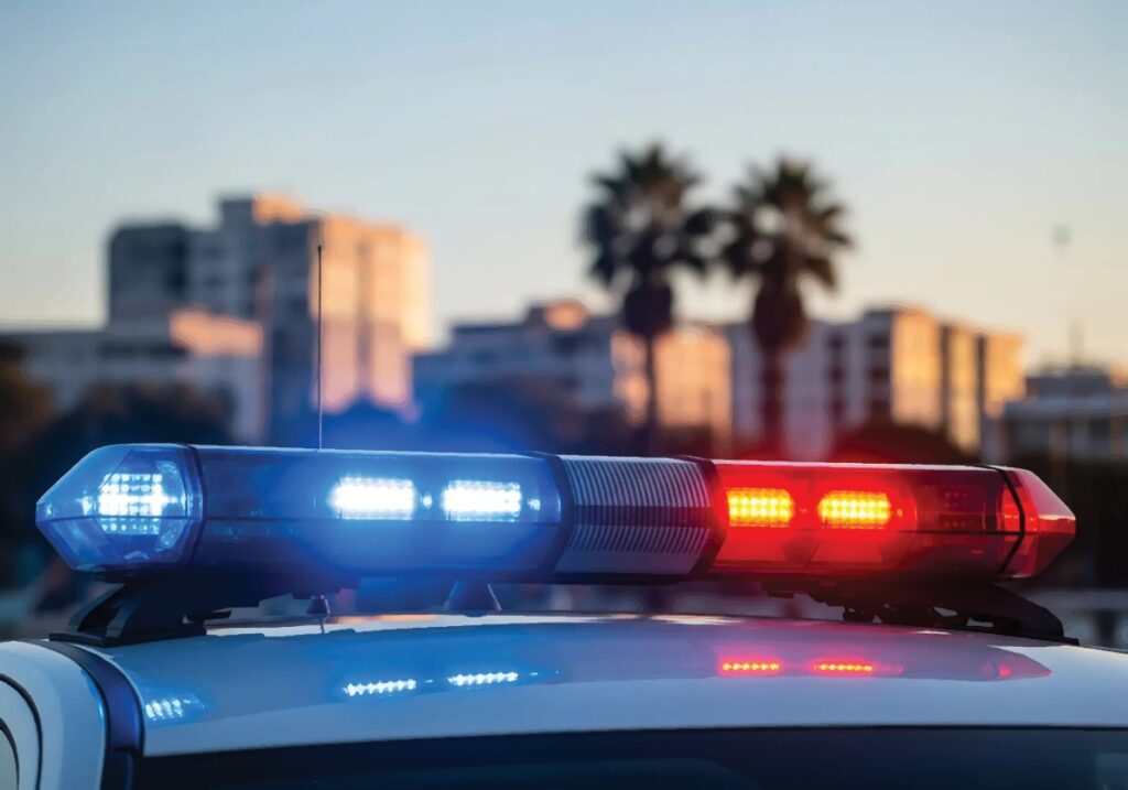 A light bar illuminates on top of a police cruiser.
