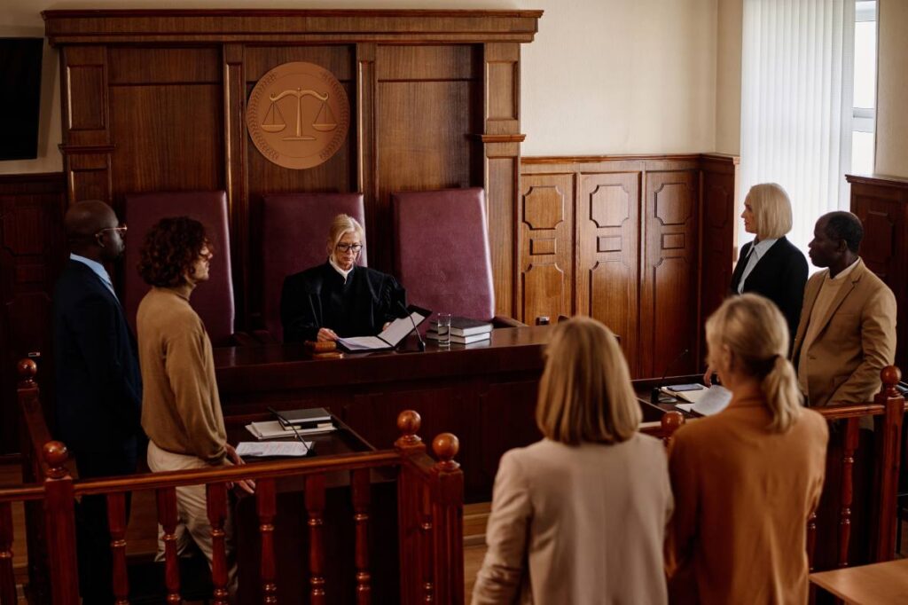 A judge, lawyers, and person being arraigned in a courtroom.