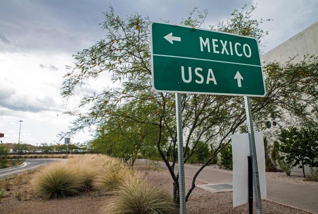 A signpost points toward the US and Mexico at the international border.